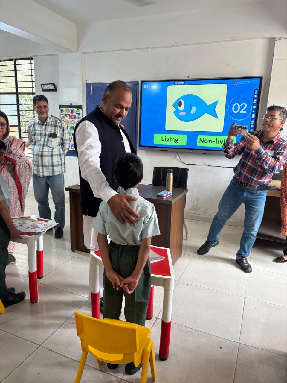 Waqf Chairman observing an interactive classroom display